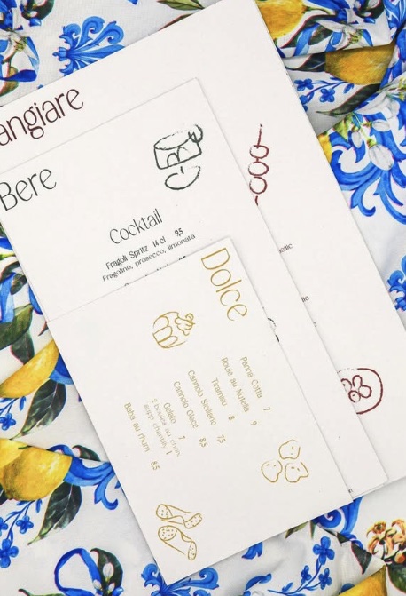 Les cartes Mangiare, Bere et Dolce sur une nappe sicilienne