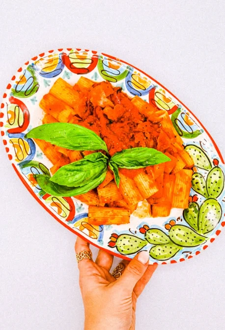Assiette de rigatoni tenue à la main
